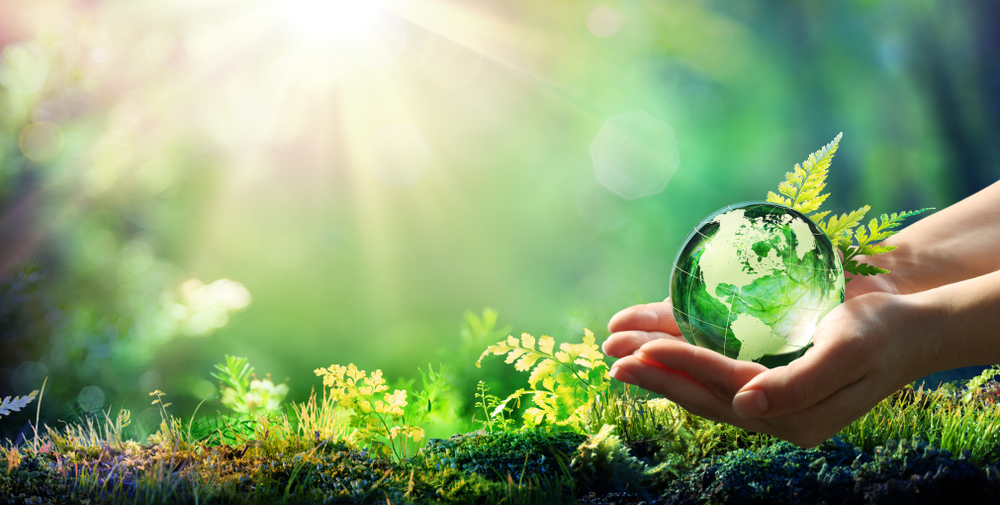 holding a glass ball in a clean countryside environment helped by recycling metal